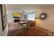 Cozy living room features comfortable seating, a ceiling fan, and a decorative sunburst mirror at 312 Sailwinds Rd, Mooresville, NC 28115
