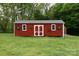 Exterior view of the backyard red building, with windows on both sides, blending with the surrounding greenery at 3199 Harmony Rd, Catawba, SC 29704