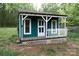 Quaint blue shed with a charming porch and white picket fence detail at 3199 Harmony Rd, Catawba, SC 29704