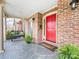 Inviting front porch with a bench, potted plants, brick accents, and a vibrant red front door at 3625 Mill Pond Rd, Charlotte, NC 28226