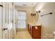 Neutral bathroom featuring a wood vanity, white countertops, and an oval mirror at 4427 Brandie Glen Rd, Charlotte, NC 28269