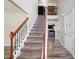 A carpeted staircase with wooden handrail and decorative wrought iron spindles at 4427 Brandie Glen Rd, Charlotte, NC 28269