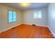 Spacious bedroom with hardwood floors and natural light from two windows at 4800 Kipling Dr, Charlotte, NC 28212
