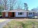 Charming single-story home with a red brick exterior, gray siding, and mature trees in a well-established neighborhood at 4800 Kipling Dr, Charlotte, NC 28212