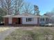 Charming single-story home with a red brick exterior, gray siding, and mature trees in a well-established neighborhood at 4800 Kipling Dr, Charlotte, NC 28212