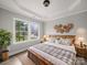 Comfortable bedroom features a large window, soft lighting, and a decorative headboard to create a serene retreat at 5101 Thornhill Dr, Gastonia, NC 28052