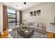 Living room featuring hardwood floors, neutral decor, a large window, and modern furnishings at 525 E Sixth St # 208, Charlotte, NC 28202