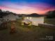 Large backyard features a fenced yard, playset, fire pit, and covered patio area at 5405 Austin Rd, Monroe, NC 28112