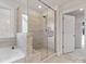 A modern glass shower, with a seat, is next to a bathtub and a closet in this bathroom at 5585 Zeeland Ln, Fort Mill, SC 29707