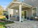 Relaxing covered patio with comfortable seating, stylish string lights, and a tranquil backyard view at 5585 Zeeland Ln, Fort Mill, SC 29707