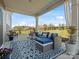 Charming covered patio with elegant seating, a patterned rug, and views of the serene backyard at 5585 Zeeland Ln, Fort Mill, SC 29707