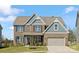 Charming two-story brick home with a well-manicured lawn and attached two car garage at 5585 Zeeland Ln, Fort Mill, SC 29707