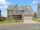 Charming two-story home with a brick facade, covered entrance, two-car garage, and well-maintained lawn at 5585 Zeeland Ln, Fort Mill, SC 29707