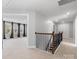 Hallway with wood and black iron railing leads to rooms bathed in natural light at 5585 Zeeland Ln, Fort Mill, SC 29707
