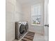 Modern laundry room features new gray machines, open shelving and a window with backyard views at 5585 Zeeland Ln, Fort Mill, SC 29707