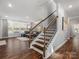 Open-concept living room with hardwood floors, a staircase, and lots of natural light at 5585 Zeeland Ln, Fort Mill, SC 29707