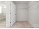 Empty walk-in closet featuring wire shelving, carpeted floor, and a view into the ensuite bathroom at 5585 Zeeland Ln, Fort Mill, SC 29707