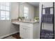 Bathroom vanity features granite counters, white cabinets, decor and a leaning towel rack with gray towels at 6015 Ahoskie Dr, Charlotte, NC 28215