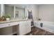 Bathroom featuring double sink vanity with granite counters, soaking tub, and ladder towel rack at 6015 Ahoskie Dr, Charlotte, NC 28215