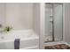 Bathroom features a white tub and a walk-in shower with glass doors and neutral walls at 6015 Ahoskie Dr, Charlotte, NC 28215