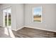 Bright bedroom features wood-look flooring, a sliding glass door, and a window offering natural light at 6015 Ahoskie Dr, Charlotte, NC 28215