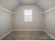 Neutral bedroom closet with wall to wall carpet, a window, and wire shelving at 6015 Ahoskie Dr, Charlotte, NC 28215