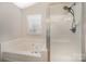 Bathroom featuring a large tub and a separate glass enclosed shower with brushed nickel hardware at 6027 Edinmeadow Ln # 29, Charlotte, NC 28269
