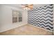 Bedroom with a modern blue and white zigzag accent wall, a ceiling fan, and a window at 6027 Edinmeadow Ln # 29, Charlotte, NC 28269