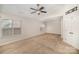 Bright bedroom featuring neutral carpet, ceiling fan, and large windows for natural light at 6027 Edinmeadow Ln # 29, Charlotte, NC 28269