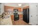 Kitchen features wood cabinetry, granite countertops, black appliances, and durable floors at 6027 Edinmeadow Ln # 29, Charlotte, NC 28269