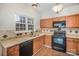 Kitchen features wood cabinets, granite counters, modern appliances, and views to the yard at 6027 Edinmeadow Ln # 29, Charlotte, NC 28269