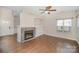 Spacious living room with hardwood floors, fireplace with tiled hearth, and built-in shelving at 6027 Edinmeadow Ln # 29, Charlotte, NC 28269