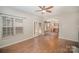 Bright living room with hardwood floors, ceiling fan, and views to the kitchen and outdoor patio at 6027 Edinmeadow Ln # 29, Charlotte, NC 28269