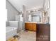 Bright bathroom featuring a soaking tub, walk-in shower, and double sink vanity with tile flooring at 7003 Dacian Ln, Indian Trail, NC 28079