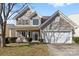 Charming two-story home featuring a welcoming front porch and a two-car garage with well-maintained landscaping at 7003 Dacian Ln, Indian Trail, NC 28079
