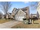 Side view of a tan house showing the driveway and landscaping at 7003 Dacian Ln, Indian Trail, NC 28079