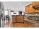 Well-equipped kitchen featuring stainless steel appliances, stone countertops, and wood cabinets at 7003 Dacian Ln, Indian Trail, NC 28079