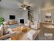 Bright, staged living room featuring a fireplace, modern ceiling fan and dining area at 725 Rock Lake Gln, Fort Mill, SC 29715