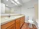 Bathroom with a large vanity, single sink, tile shower, and wood-look floors at 7340 Winery Ln, Charlotte, NC 28227