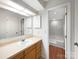 Well-lit bathroom with a vanity, large mirror, and a separate room featuring a tub and shower combo at 7340 Winery Ln, Charlotte, NC 28227