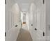 Hallway lined with doors, offering access to various rooms and storage, with a view into a bathroom at 7340 Winery Ln, Charlotte, NC 28227