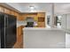 Kitchen with wooden cabinets, black appliances, and a breakfast bar overlooking a bright living area at 7340 Winery Ln, Charlotte, NC 28227