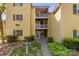 Charming condo exterior with yellow siding, blue shutters, and a welcoming entrance with multiple balconies at 766 Marsh Rd # Apt 2, Charlotte, NC 28209