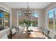 Dining room with modern lighting fixture and view of the backyard swimming pool at 805 Hidden Pond Ln, Waxhaw, NC 28173