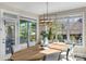 Bright dining area with stylish chandelier and views of the lush backyard and pool at 805 Hidden Pond Ln, Waxhaw, NC 28173