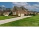 Beautiful brick home showcasing a well-manicured lawn, long driveway, and two car garage at 805 Hidden Pond Ln, Waxhaw, NC 28173