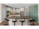 Open kitchen with black marble countertops, center island with barstool seating, and green cabinets at 805 Hidden Pond Ln, Waxhaw, NC 28173