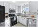 Bright kitchen with white cabinets, modern appliances, and a view of the outdoor scenery at 8409 Backer Ln, Fort Mill, SC 29707