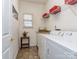 Bright laundry room features white washer and dryer with storage cabinet and tiled floor at 841 Platinum Dr, Fort Mill, SC 29708