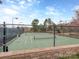 Fenced tennis court with lighting for evening play and green surface at 841 Platinum Dr, Fort Mill, SC 29708